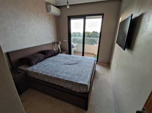 a small bedroom with a bed and a window at Appartement beau lieu plage Manisman in Mohammedia