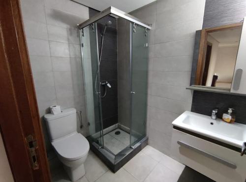 a bathroom with a shower and a toilet and a sink at Appartement beau lieu plage Manisman in Mohammedia