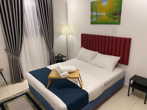 a small bedroom with a bed with a red headboard at Reylin Alanis Suite // Free Wifi & Netflix // Airport Shuttle Service in Sepang