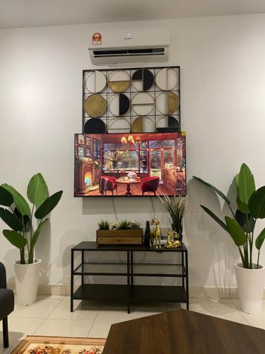 a living room with a table and a painting on the wall at Reylin Alanis Suite // Free Wifi & Netflix // Airport Shuttle Service in Sepang