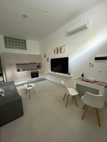 a large white living room with a couch and chairs at Casa Don Saro in Giardini Naxos