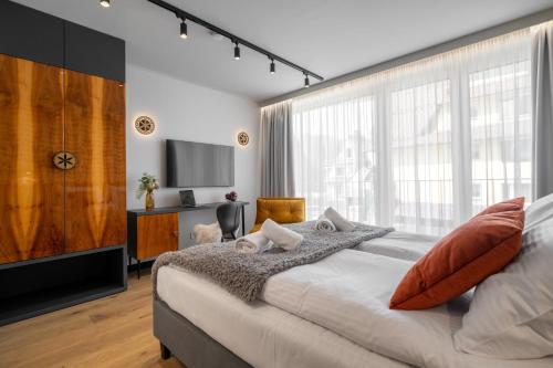 a bedroom with a large bed and a tv at Tatry Mozaika Willa PREMIUM & SPA - Sauna, Jacuzzi, Flipper by RentiloPL in Zakopane