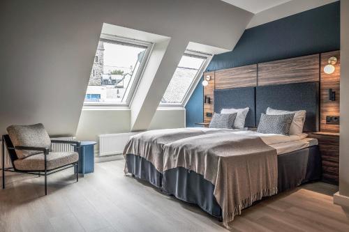 a bedroom with a large bed and a chair at Quality Hotel Waterfront in Ålesund