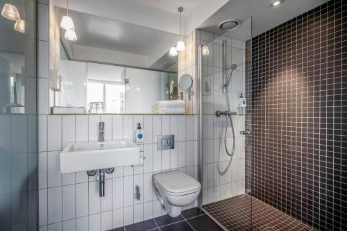 a bathroom with a toilet and a sink and a shower at Quality Hotel Waterfront in Ålesund