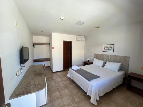 Habitación de hotel con cama y TV en Pousada Maristella en Salvador