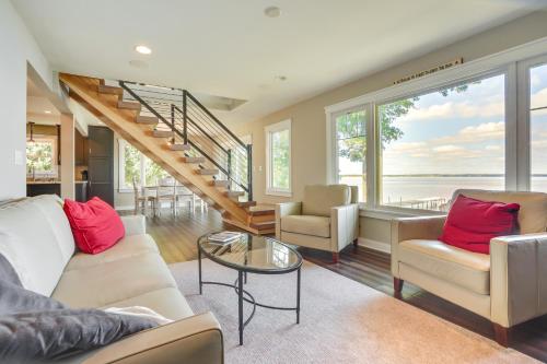 a living room with a couch and chairs and a staircase at Lakefront Chippewa Falls Haven with Private Deck! in Chippewa Falls