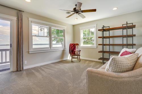 a living room with a ceiling fan and windows at Lakefront Chippewa Falls Haven with Private Deck! in Chippewa Falls