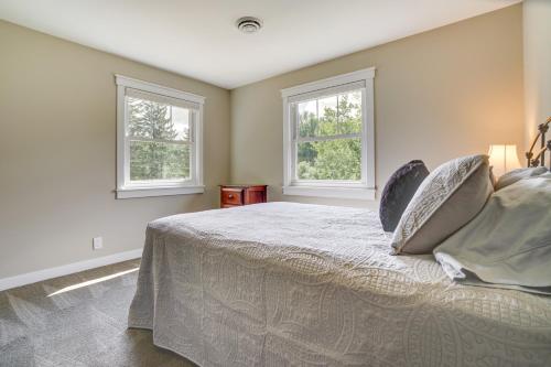 1 dormitorio con 1 cama y 2 ventanas en Lakefront Chippewa Falls Haven with Private Deck!, en Chippewa Falls