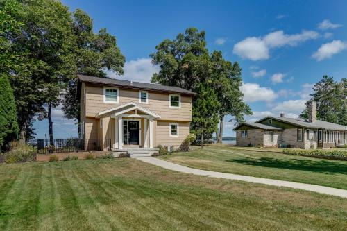 a large house with a grassy yard at Lakefront Chippewa Falls Haven with Private Deck! in Chippewa Falls