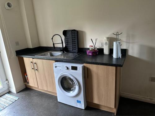 a kitchen with a washing machine and a sink at Barons Place in Birmingham