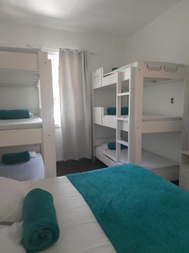 a bedroom with two bunk beds and a green pillow on a bed at Hotel Cidade Imperial in Petrópolis