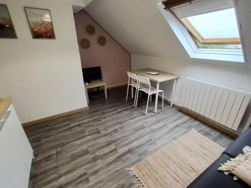 Cette chambre mansardée comprend une table et des chaises. dans l'établissement Studio Bohème, Proche Hyper Centre et Commerces, à Valenciennes