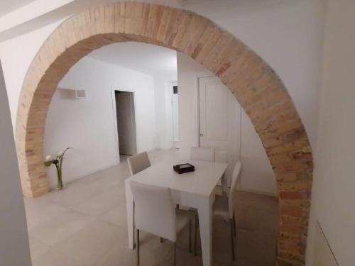 a dining room with a white table and an archway at Alessandro Luxury Home Rome in Rome