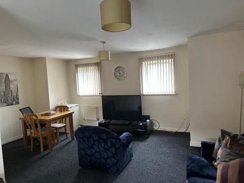 a living room with a tv and a table and chairs at Barons Place in Birmingham