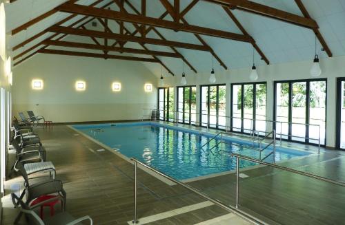 a large indoor swimming pool with chairs and a large pool at Loire & Sens in Juigné-sur-Loire