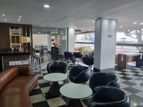 a lobby with couches and tables and chairs at Tropical Barra Hotel in Rio de Janeiro