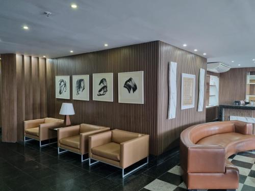 a waiting room with chairs and pictures on the wall at Tropical Barra Hotel in Rio de Janeiro