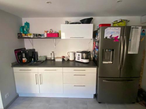 una cucina con frigorifero e armadietti bianchi di Maison de 3 chambres avec jardin clos et wifi a Dreux a Dreux