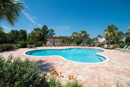 a swimming pool in a yard with a brick patio at Avian Forest Four Bedroom, Three Bath, Golf Villa in Pawleys Island