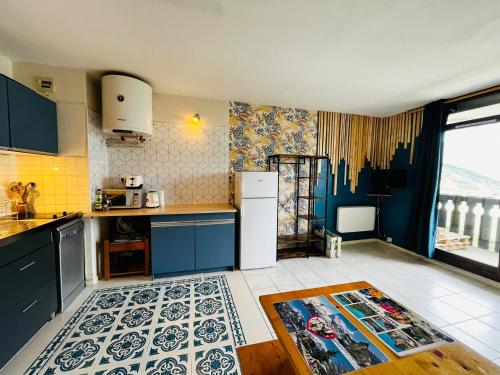La cuisine est équipée de placards bleus et d'un réfrigérateur blanc. dans l'établissement Studio cosy 5 personnes, à Saint-Lary-Soulan