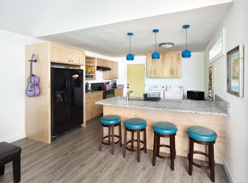 a kitchen with a bar with blue stools at Folly Vacation Fantastic Vibe! Incredible Apt D in Folly Beach