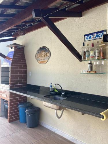a kitchen with a sink and a sign on the wall at Casa Brisas Arembepe - arejada e aconchegante - litoral norte da Bahia - WiFi in Arembepe