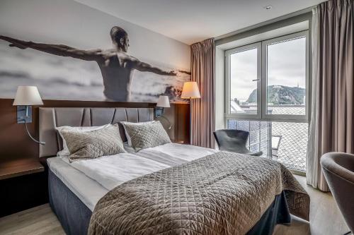 a bedroom with a bed and a large window at Quality Hotel Waterfront in Ålesund