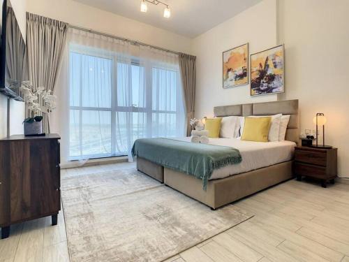 a bedroom with a large bed and a large window at Key View - Orchid Residence in Dubai