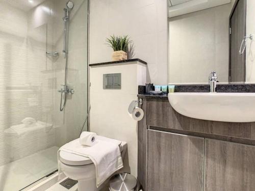 a bathroom with a toilet and a sink and a shower at Key View - Orchid Residence in Dubai