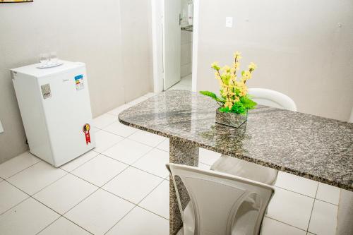 a kitchen with a counter with a sink and a refrigerator at Letiva Hotel Centro in Sobral
