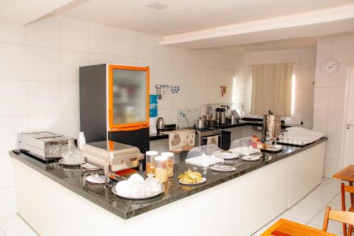 a kitchen with a counter with food on it at Letiva Hotel Centro in Sobral