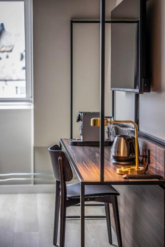 a kitchen with a wooden table and a chair at Quality Hotel Waterfront in Ålesund