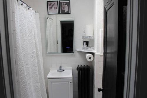 a white bathroom with a sink and a mirror at Comfy! Cozy! Spacious! in Eastpointe