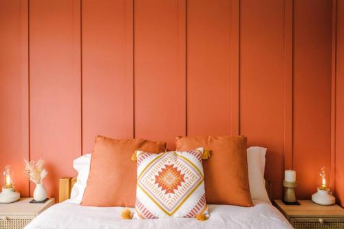 a bed with orange walls and pillows on it at Elegant 2BD Family Retreat Blackpool Town in Blackpool