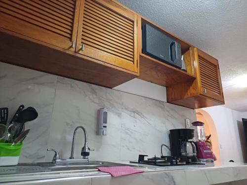a kitchen with a sink and a microwave at Casa Las Palmas in Cancún