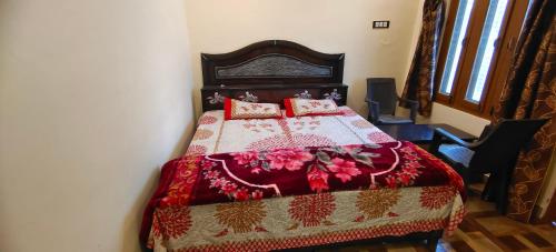 a bedroom with a bed with a red blanket and pillows at hotel chakrata green and camping in Chakrāta
