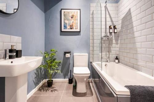 ein Badezimmer mit einer Badewanne, einem WC und einem Waschbecken in der Unterkunft Duck Cottage - Cosy Cottage - Central Location in Haworth