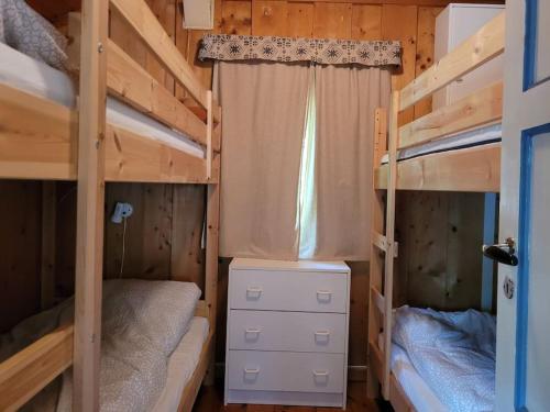 a bedroom with two bunk beds and a window at Idyllic lakeside cabin (hytte) in Horten