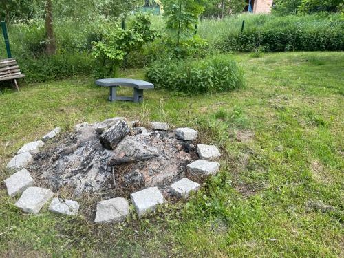 a stone fire pit in a yard with a bench at Exkluzivní chalupa Podještědka s grilem a saunou in Světlá pod Ještědem
