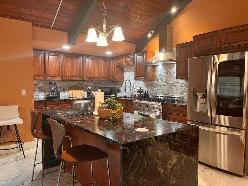 a kitchen with wooden cabinets and a stainless steel refrigerator at Serene Oasis Getaway with Sauna and a swim spa. in Portland