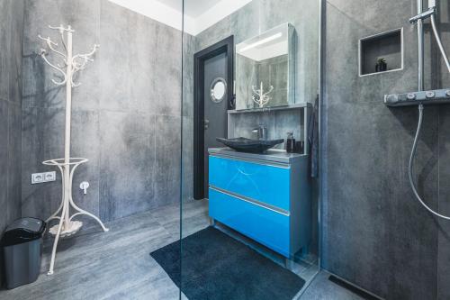 een badkamer met een blauwe wastafel en een spiegel bij Unique in Eger