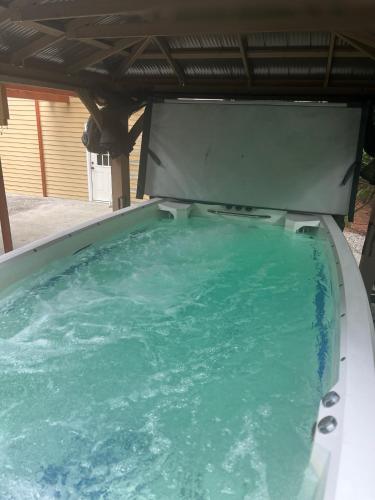 a large pool of blue water in a backyard at Serene Oasis Getaway with Sauna and a swim spa. in Portland