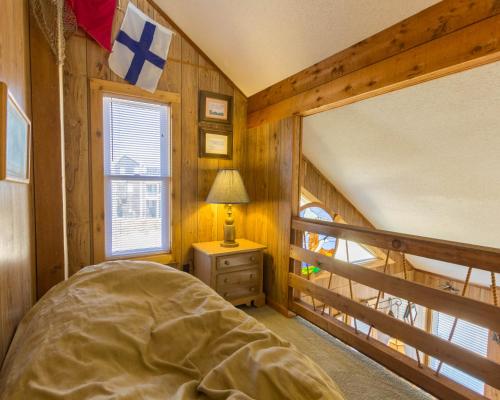 a bedroom with a bed in a room with wooden walls at 7026 - Southwind by Resort Realty in Rodanthe