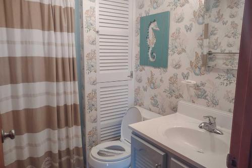 a bathroom with a toilet and a sink at 7026 - Southwind by Resort Realty in Rodanthe