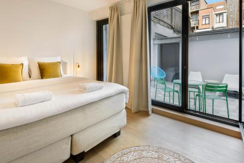 a bedroom with a large bed and a balcony at R73 Apartments by Domani Hotels in Antwerp
