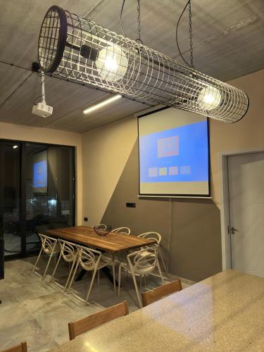 a room with a table and a projection screen at Alpine Escape Kazbegi in Stepantsminda