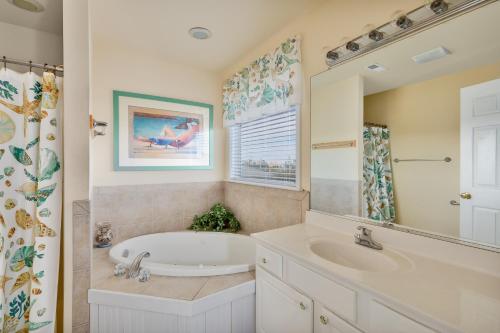 a bathroom with a tub and a sink at 7030 - Waves Against the Machine by Resort Realty in Rodanthe