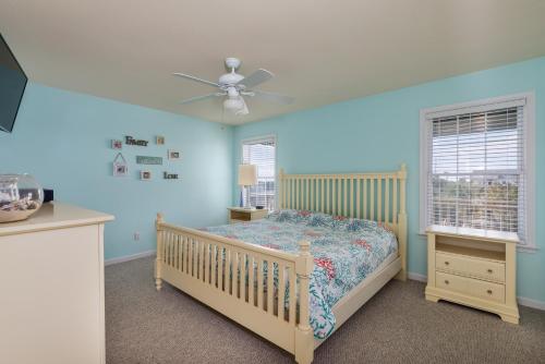 a bedroom with a bed and a ceiling fan at 7030 - Waves Against the Machine by Resort Realty in Rodanthe