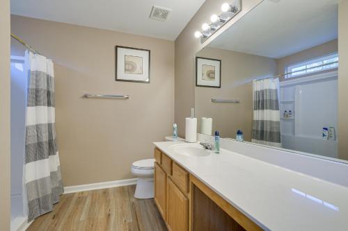 ein Badezimmer mit einem Waschbecken, einem WC und einem Spiegel in der Unterkunft Raleigh Home with Screened Porch 8 Mi to Downtown! in Raleigh