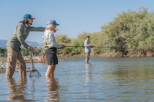a group of people standing in the water fishing at Sage Lodge in Pray
